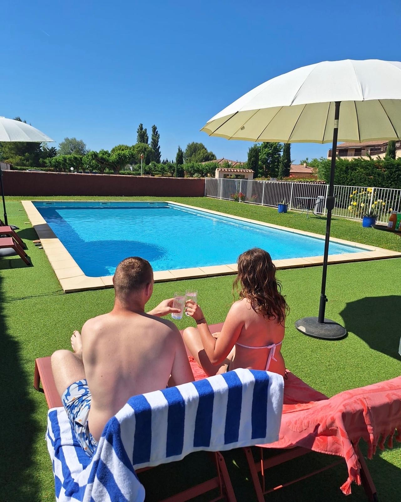 Couple savourant une boisson au bord de la piscine de l'Hôtel La Perna