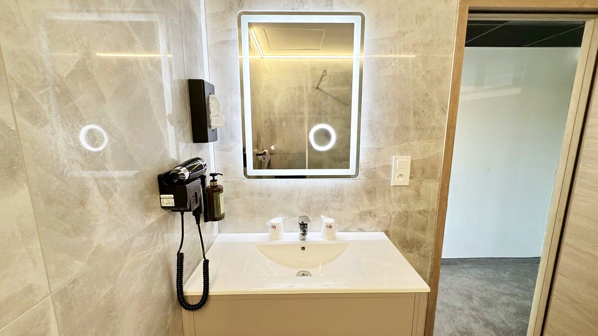 Salle de bain de la Chambre Prestige — vasque et miroir éclairé