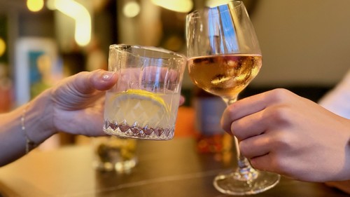 Verres qui trinquent au bar de l'Hôtel La Perna — pause gourmande au bord de la piscine
